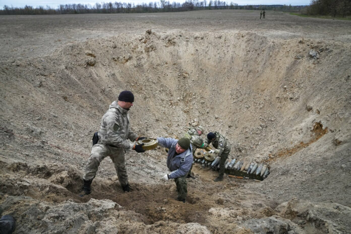 Interior ministry sappers collect explosives in a hole to detonate them near a mine field after recent battles at the village of Moshchun close to Kyiv, Ukraine, Tuesday, April 19, 2022. Photo: Efrem Lukatsky / AP
