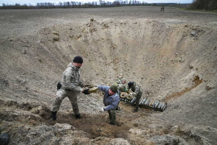 Interior ministry sappers collect explosives in a hole to detonate them near a mine field after recent battles at the village of Moshchun close to Kyiv, Ukraine, Tuesday, April 19, 2022. Photo: Efrem Lukatsky / AP Interior ministry sappers collect explosives in a hole to detonate them near a mine field after recent battles at the village of Moshchun close to Kyiv, Ukraine, Tuesday, April 19, 2022. Photo: Efrem Lukatsky / AP