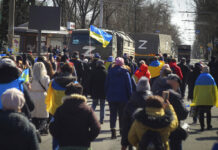Occupied Ukrainian City Fears Sham Russian Referendum Plans People with Ukrainian flags walk towards Russian army trucks during a rally against the Russian occupation in Kherson, Ukraine, Sunday, March 20, 2022. Photo: Olexandr Chornyi / AP