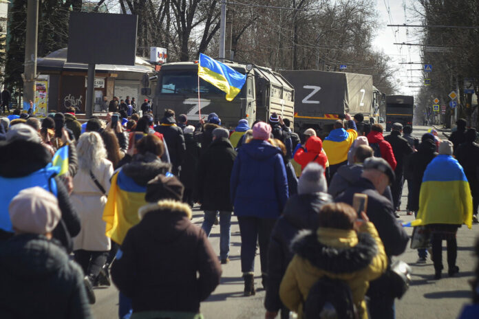 People with Ukrainian flags walk towards Russian army trucks during a rally against the Russian occupation in Kherson, Ukraine, Sunday, March 20, 2022. Photo: Olexandr Chornyi / AP