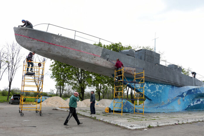 Municipal workers clean and paint a Soviet style torpedo boat preparing to celebrate 77 years of the victory in WWII in Mariupol, in territory under the government of the Donetsk People's Republic, eastern Ukraine, Thursday, May 5, 2022. Photo: AP