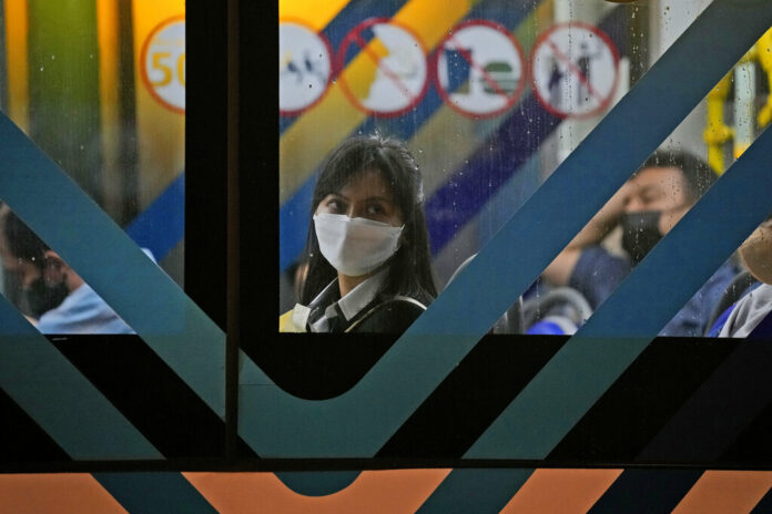 A woman wearing a mask to curb the spread of coronavirus sits inside a bus in Jakarta, Indonesia, Tuesday, May 17, 2022. Photo: Dita Alangkara / AP