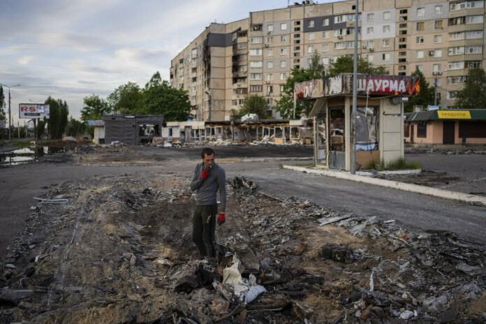 A man searches for metal scraps in a shelled neighbourhood in Kharkiv, eastern Ukraine, Thursday, May 19, 2022. Photo: Bernat Armangue / AP