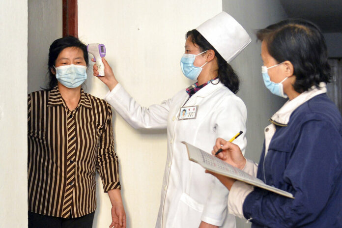 FILE - In this photo provided by the North Korean government, a doctor checks a resident's temperature to curb the spread of coronavirus infection, in Pyongyang, North Korea on May 17, 2022. Photo: Korean Central News Agency / Korea News Service via AP File