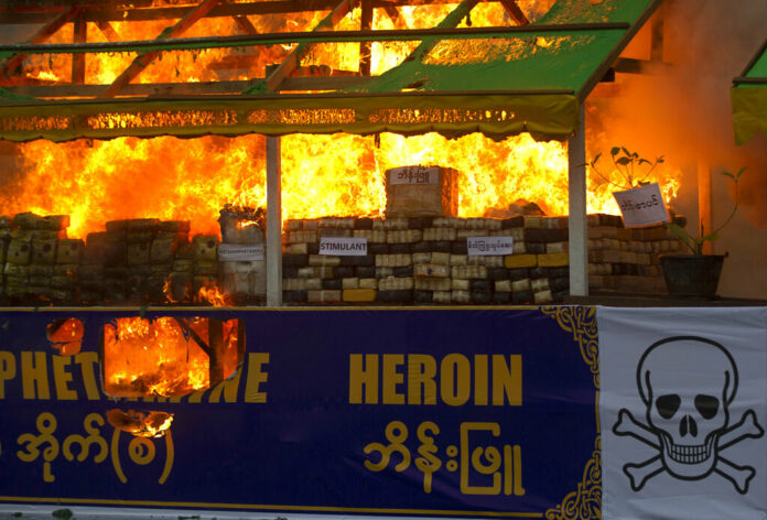 FILE - Smokes and flames billow from burning narcotic drugs during a destruction ceremony of seized narcotic drugs in outskirts of Yangon, Myanmar on June 26, 2018. Photo: Thein Zaw / AP File