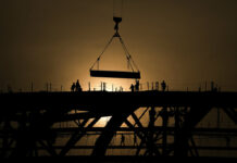 Carbon Emissions Dip, at Least Briefly, in China, Study Says FILE - Workers are silhouetted against a sunset as they handle a steel frame on the roof of the Workers' Stadium under construction in Beijing, China, Monday, Feb. 28, 2022. Photo: Andy Wong / AP File