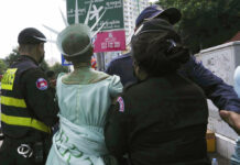 Cambodian Court Convicts Lawyer, Dozens of Others of Treason Cambodian-American lawyer Theary Seng, center, dressed in the Lady Liberty, is escorted by local police officers outside Phnom Penh Municipal Court in Phnom Penh, Cambodia, Tuesday, June 14, 2022. Photo: Heng Sinith / AP