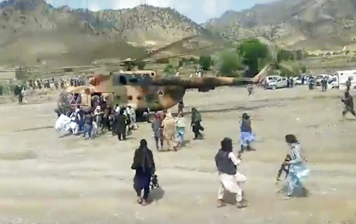 In this image taken from video from Bakhtar State News Agency, Taliban fighters secure a government helicopter to evacuate injured people in Gayan district, Paktika province, Afghanistan, Wednesday, June 22, 2022. Photo: Bakhtar State News Agency via AP