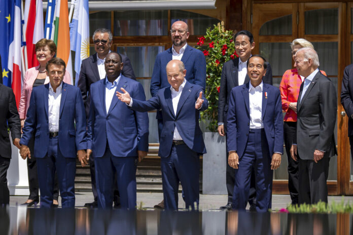 German Chancellor Olaf Scholz, centre stands between from foreground left, Emmanuel Macron, President of France, Macky Sall, President of Senegal, Jako Widodo, President of Indonesia, and U.S. President Joe Biden for a group photo with the outreach guests, at the G7 summit, in Kruen, Germany, Monday, June 27, 2022. Photo: Michael Kappeler / Pool Photo via AP