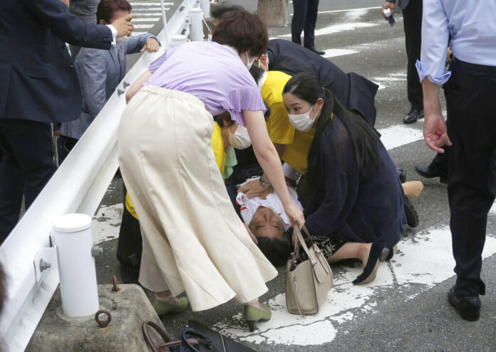 Japan’s former Prime Minister Shinzo Abe, center, falls on the ground in Nara, western Japan Friday, July 8, 2022. Photo: Kyodo News via AP