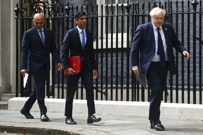 From left, British Health Secretary Sajid Javid, Chancellor of the Exchequer Rishi Sunak and Prime Minister Boris Johnson arrive at No 9 Downing Street for a media briefing on May 7, 2021. Photo: Toby Melville / PA via AP