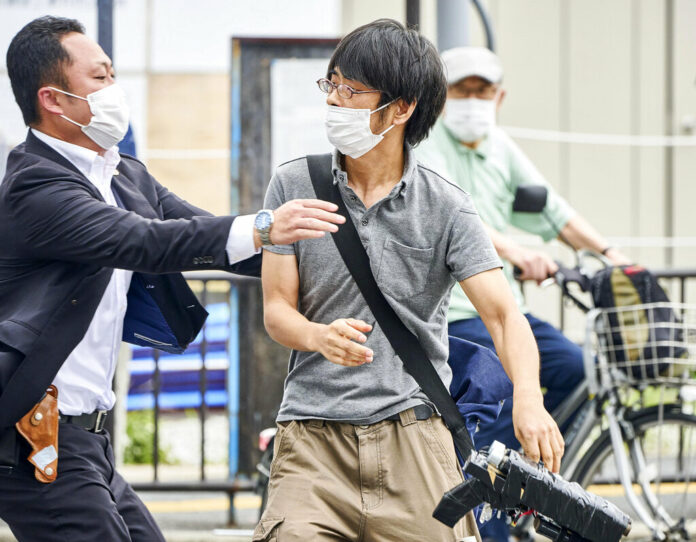 FILE - Tetsuya Yamagami, center, holding a weapon, is detained near the site of gunshots in Nara, western Japan, Friday, July 8, 2022. The 40-centimeter-long (16-inch) firearm that was used to kill former Prime Minister Shinzo Abe on Friday as he campaigned for his ruling party in Nara, western Japan, looked crude, more like a propellant made of pipes taped together and filled with explosives. Photo: Nara Shimbun / Kyodo News via AP File FILE - Tetsuya Yamagami, center, holding a weapon, is detained near the site of gunshots in Nara, western Japan, Friday, July 8, 2022. The 40-centimeter-long (16-inch) firearm that was used to kill former Prime Minister Shinzo Abe on Friday as he campaigned for his ruling party in Nara, western Japan, looked crude, more like a propellant made of pipes taped together and filled with explosives. Photo: Nara Shimbun / Kyodo News via AP File