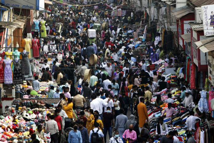 FILE - Indians wearing face masks as a precaution against the COVID-19, crowd a market, in Mumbai, India, on Jan. 7, 2022. Photo: Rajanish Kakade / AP File