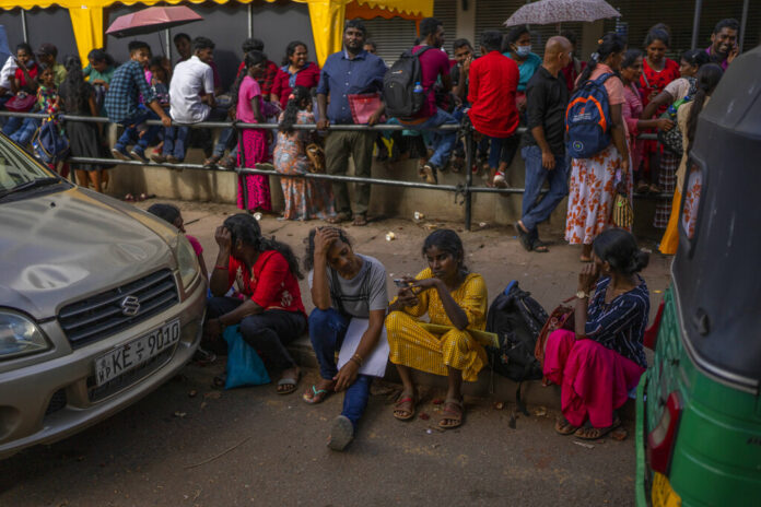People wait in queue to get their passports outside Department of Immigration & Emigration in Colombo, Sri Lanka, Monday, July 18, 2022. Photo: Rafiq Maqbool / AP
