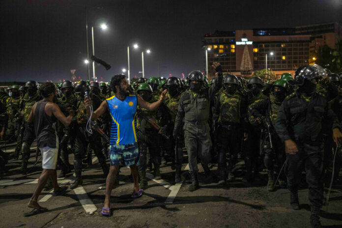 A protester shouts slogans as army soldiers arrive to remove protesters from the site of a protest camp outside the Presidential Secretariat in Colombo, Sri Lanka, Friday, July 22, 2022. Photo: Rafiq Maqbool / AP