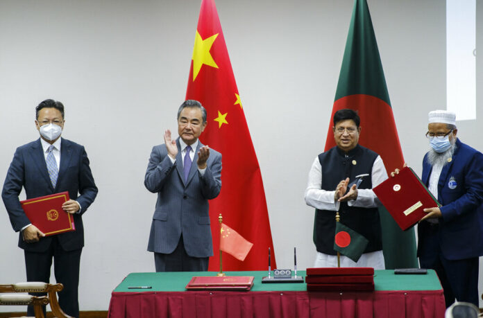 Chinese Foreign Minister Wang Yi, center left, and his Bangladeshi counterpart A.K. Abdul Momen applaud as both countries sign agreements in Dhaka, Bangladesh, Sunday, Aug.7, 2022. Photo: Mahmud Hossain Opu / AP