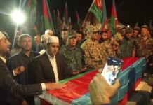 Cease-fire Holds Between Armenia and Azerbaijan In this image taken from video, people stand around a coffin of Azeri serviceman Elshan Babazade killed at Azerbaijani-Armenian border, during his funeral in Mykhlygovag, Azerbaijan, Tuesday, Sept. 13, 2022. Photo: AP