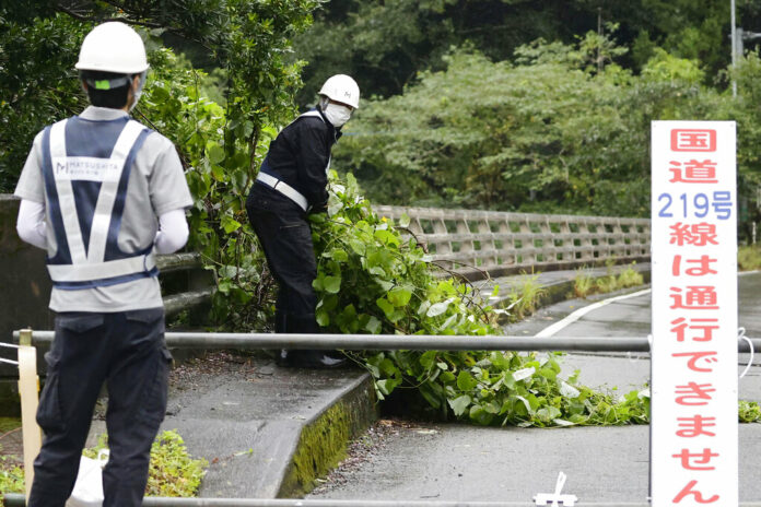 Workers clear debris broken by strong winds as a powerful typhoon hits the area in Kumamoto, southwestern Japan, Monday Sept. 19, 2022. Photo: Kyodo News via AP