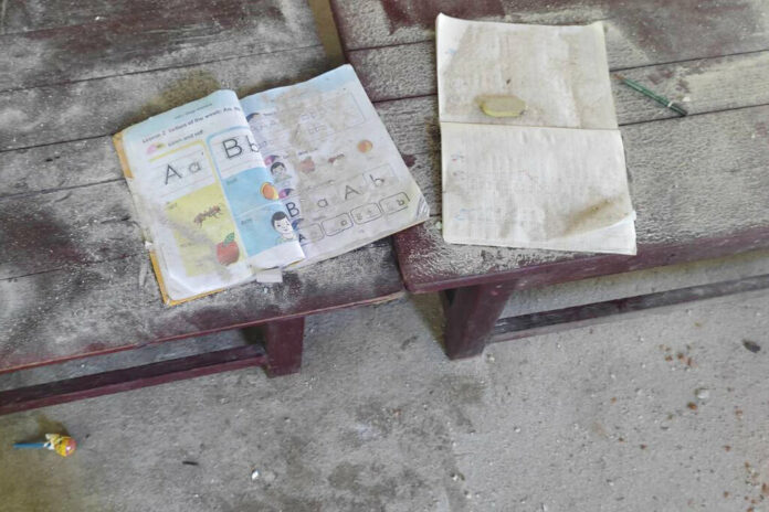 An alphabet book and a notebook lie on top of an elevated wooden floorboard of a middle school in Let Yet Kone village in Tabayin township in the Sagaing region of Myanmar on Saturday, Sept. 17, 2022, the day after an air strike hit the school. Photo: AP