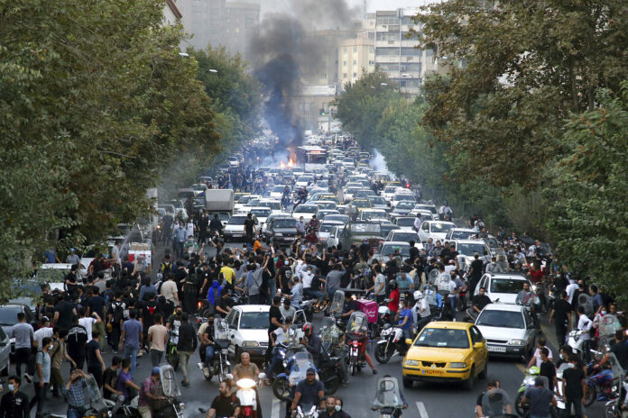 In this Wednesday, Sept. 21, 2022, photo taken by an individual not employed by the Associated Press and obtained by the AP outside Iran, protesters chant slogans during a protest over the death of a woman who was detained by the morality police, in downtown Tehran, Iran. Photo: AP