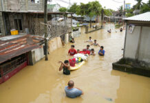 Powerful Typhoon Leaves 5 Rescuers Dead in North Philippines Residents give out free food as they wade through a flooded street in their village from Typhoon Noru in San Miguel town, Bulacan province, Philippines, Monday, Sept. 26, 2022. Photo: Aaron Favila / AP