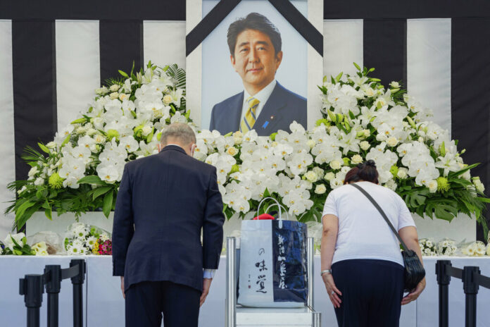 People leave flowers and pay their respects to former Japanese Prime Minister Shinzo Abe outside the Nippon Budokan in Tokyo Tuesday, Sept. 27, 2022, ahead of his state funeral later in the day. Photo: Nicolas Datiche / Pool Photo via AP