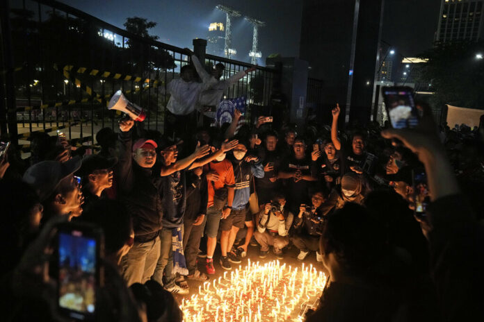Indonesian soccer fans chant slogans during a candle light vigil for the victims of Saturday's soccer riots, in Jakarta, Indonesia, Sunday, Oct. 2, 2022. Photo: Dita Alangkara / AP Indonesian soccer fans chant slogans during a candle light vigil for the victims of Saturday's soccer riots, in Jakarta, Indonesia, Sunday, Oct. 2, 2022. Photo: Dita Alangkara / AP