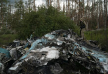 Russian Rockets Slam Into Ukrainian City Near Nuclear Plant A Ukrainian serviceman walks over the remains of Russian aircraft SU-34 in an area at the recaptured town of Lyman, Ukraine, Wednesday, Oct. 5, 2022. Photo: Leo Correa / AP
