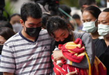 Thailand Mourns Children, Others Slain by Ex-police Officer A family of a victim mourns as they bring a blanket and a milk bottle during a ceremony for those killed in the attack on the Young Children's Development Center in the rural town of Uthai Sawan, north eastern Thailand, Friday, Oct. 7, 2022. Photo: Sakchai Lalit / AP