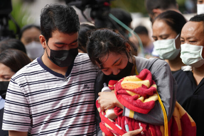 A family of a victim mourns as they bring a blanket and a milk bottle during a ceremony for those killed in the attack on the Young Children's Development Center in the rural town of Uthai Sawan, north eastern Thailand, Friday, Oct. 7, 2022. Photo: Sakchai Lalit / AP