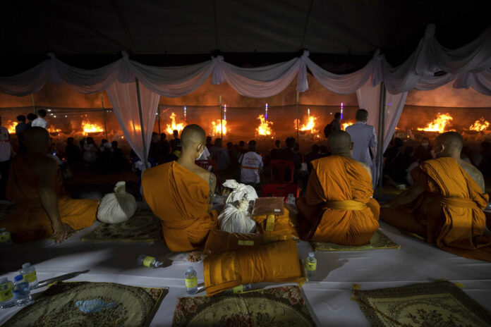 Monks sit and watch at funeral pyres set to cremate those who died in the day care center attack at Wat Rat Samakee temple in Uthai Sawan, northeastern Thailand, Tuesday, Oct. 11, 2022. Photo: Wason Wanichakorn / AP