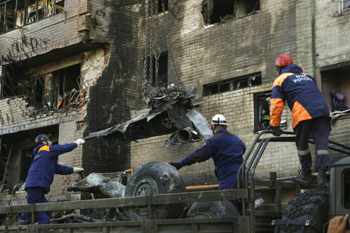 Emergency workers load debris of a warplane on a truck at the scene of a plane crash in a residential area in Yeysk, Russia, Tuesday, Oct. 18, 2022. Photo: AP