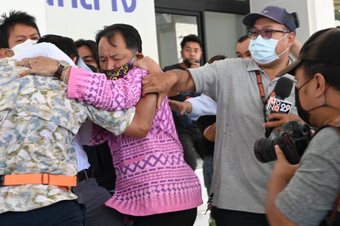 Weerawit Rungruengsiriphon, left, attacks activist Srisuwan Janya, middle, outside the Central Investigation Bureau on Oct. 18, 2022.