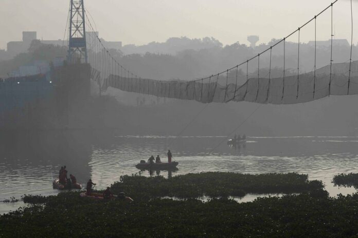 Rescuers on boats search in the Machchu river where a pedestrian bridge collapsed Sunday in Morbi town of western state Gujarat, India, Tuesday, Nov. 1, 2022. Photo: Rafiq Maqbool / AP Rescuers on boats search in the Machchu river where a pedestrian bridge collapsed Sunday in Morbi town of western state Gujarat, India, Tuesday, Nov. 1, 2022. Photo: Rafiq Maqbool / AP