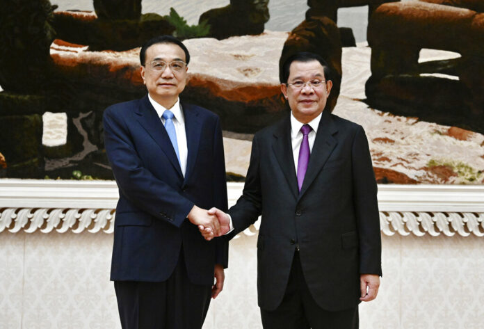 In this photo provided by Cambodia's Government Cabinet, Cambodian Prime Minister Hun Sen, right, and Chinese Premier Li Keqiang, left, shake hands during a welcome meeting at Peace Palace in Phnom Penh, Cambodia, Wednesday, Nov. 9, 2022. Photo: Kok Ky / Cambodia's Government Cabinet via AP