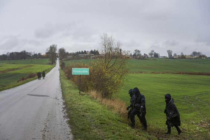 Polish police officers search for missile wreckage in the field, near the place where a missile struck, killing two people in a farmland at the Polish village of Przewodow, near the border with Ukraine, Wednesday, Nov. 16, 2022. Photo: Evgeniy Maloletka / AP