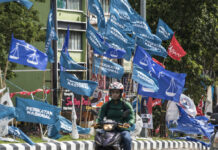 Malaysia’s Nationalist Block Closer To Forming Government Motorcycles passing by campaign flags of Malaysia's ruling National Front coalition, or Barisan Nasional (blue) and Pakatan Harapan (Alliance of Hope) coalition (red) displayed in Kuala Lumpur, Malaysia, Sunday, Nov. 20, 2022. Photo: Ahmad Yusni / AP