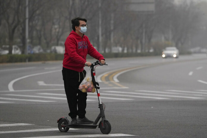 A resident rides a scooter along a quiet street in a district as restaurants are shut and residents encouraged to stay in their vicinity in Beijing, Thursday, Nov. 24, 2022. Photo: Ng Han Guan / AP A resident rides a scooter along a quiet street in a district as restaurants are shut and residents encouraged to stay in their vicinity in Beijing, Thursday, Nov. 24, 2022. Photo: Ng Han Guan / AP