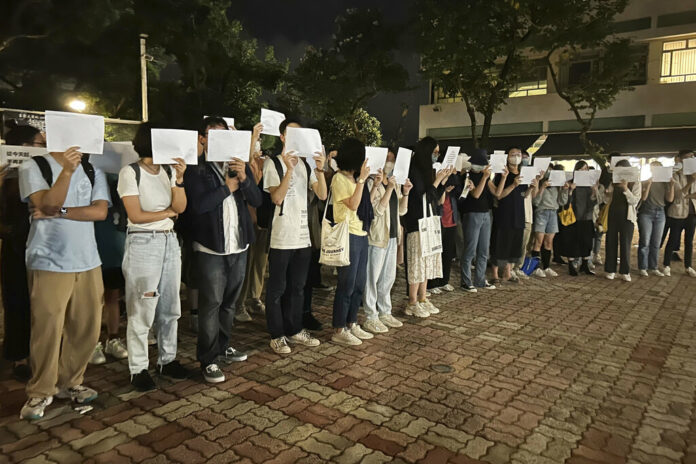 Protesters hold up blank white papers during a commemoration for victims of a recent Urumqi deadly fire at the Chinese University of Hong Kong in Hong Kong, Monday, Nov. 28, 2022. Photo: Kanis Leung / AP Protesters hold up blank white papers during a commemoration for victims of a recent Urumqi deadly fire at the Chinese University of Hong Kong in Hong Kong, Monday, Nov. 28, 2022. Photo: Kanis Leung / AP
