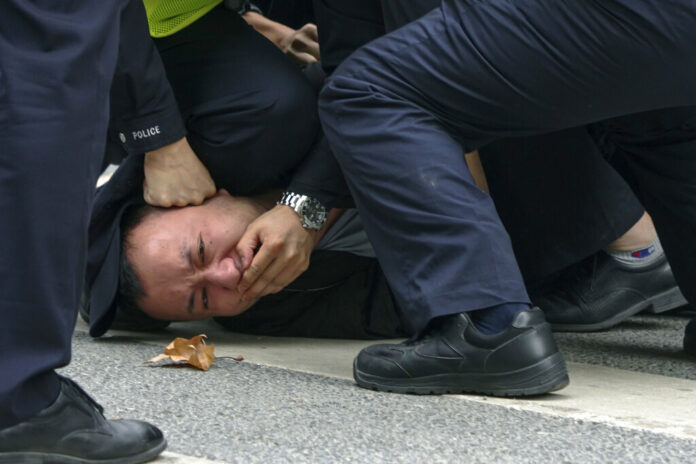 FILE - Policemen pin down and detain a protester during a protest on a street in Shanghai, China on Nov. 27, 2022. Photo: AP File