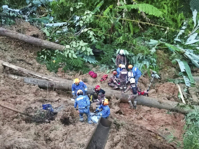 In this photo provided by Civil Defense Department, Civil Defense personnel search for missing persons after a landslide hit a campsite in Batang Kali, Malaysia, Friday, Dec. 16, 2022. Photo: Malaysia Civil Defense via AP