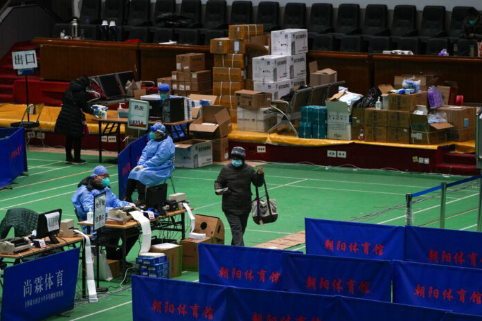 Medical workers tend to residents at a gymnasium converted into a fever clinic in Beijing, Sunday, Dec. 18, 2022. Photo: Andy Wong / AP Medical workers tend to residents at a gymnasium converted into a fever clinic in Beijing, Sunday, Dec. 18, 2022. Photo: Andy Wong / AP