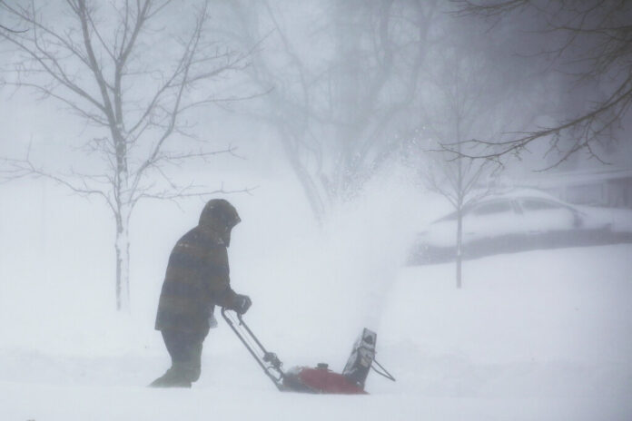 A person clears snow as a winter storm rolls through Western New York Saturday, Dec. 24, 2022, in Amherst N.Y. Photo: Jeffrey T. Barnes / AP