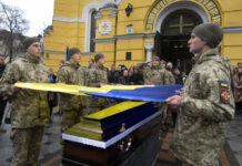 Lavrov: Ukraine Must Demilitarize or Russia Will Do It Ukrainian servicemen hold a flag over the coffin of their comrade during the funeral ceremony of Volodymyr Yezhov killed in a battlefield with Russian forces at St. Volodymyr Cathedral in Kyiv, Ukraine, Tuesday, Dec. 27, 2022. Photo: Efrem Lukatsky / AP