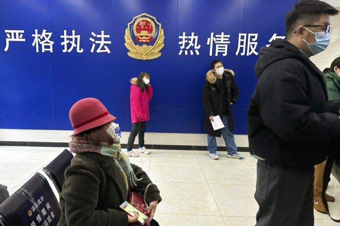 Residents line up at the community police station for document applications including for passports near the words 