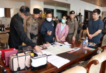 Police inspect cash and luxury items during a raid of a house in Samut Prakan province belonging to the grey business ring on Nov. 29, 2022.