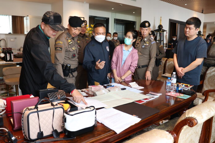 Police inspect cash and luxury items during a raid of a house in Samut Prakan province belonging to the grey business ring on Nov. 29, 2022. Police inspect cash and luxury items during a raid of a house in Samut Prakan province belonging to the grey business ring on Nov. 29, 2022.