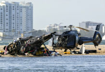Helicopters Collide Over Australian Beach, 4 People Dead Two cashed helicopters sit on the sand at a collision scene near Seaworld, on the Gold Coast, Australia, Monday, Jan. 2, 2023. Photo: Dave Hunt / AAP Image via AP