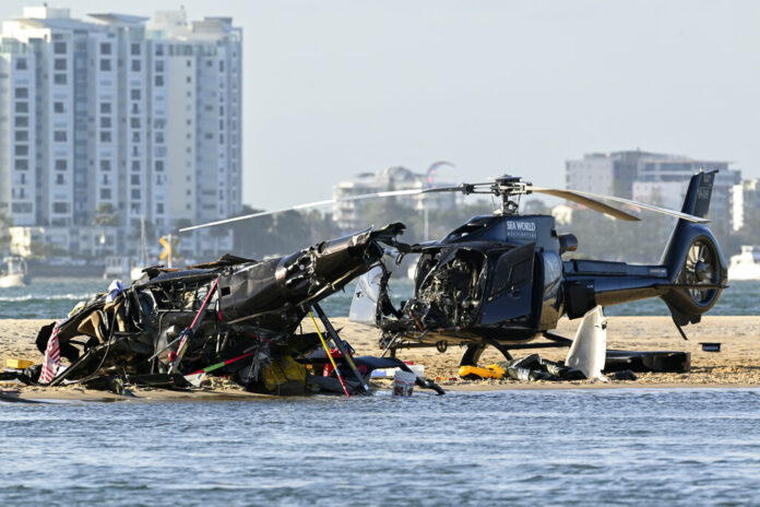 Two cashed helicopters sit on the sand at a collision scene near Seaworld, on the Gold Coast, Australia, Monday, Jan. 2, 2023. Photo: Dave Hunt / AAP Image via AP