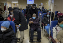 Beds Run Out at Beijing Hospital as COVID Brings More Sick A man pushes an elderly woman past patients receiving intravenous drips in the emergency ward of a hospital, Tuesday, Jan. 3, 2023. Photo: Andy Wong / AP